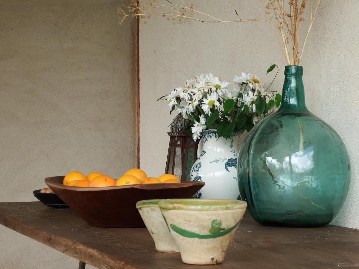una mesa con un tazón de naranjas y un jarrón en Finca Fuente Techada - Adults Only, en Sotosalbos
