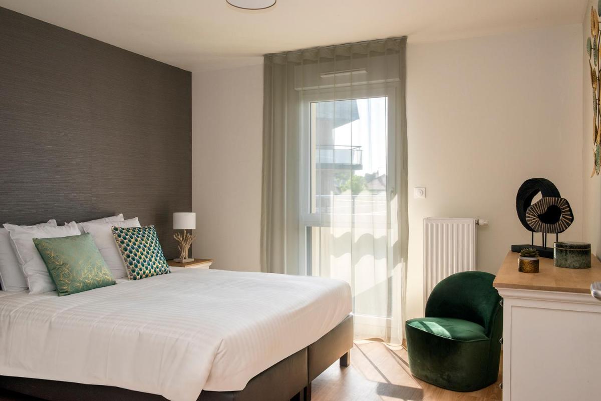 une chambre avec un lit, une chaise et une fenêtre dans l'établissement Les Boréales - Appart'hotel & Restaurant, à Villers-sur-Mer 60 autres photos