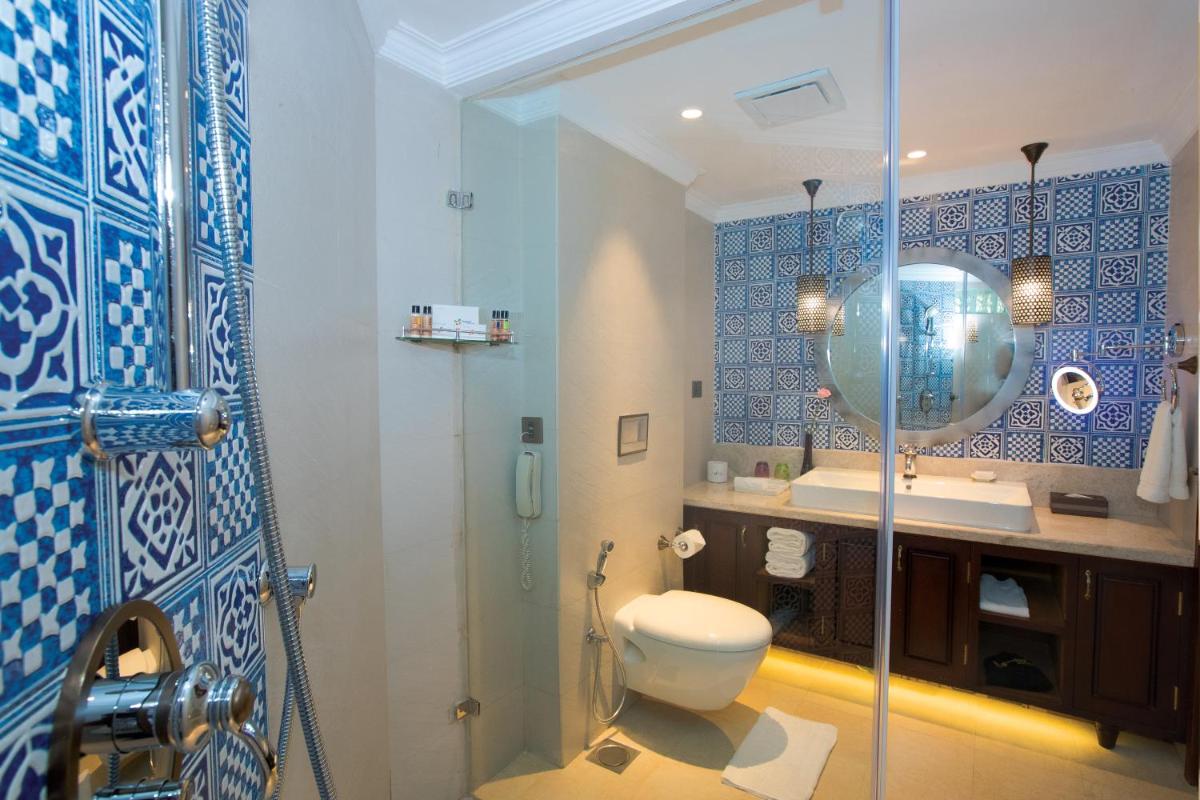 a bathroom with a toilet and a glass shower at Fragrant Nature Kochi - A Five star Classified Hotel in Cochin