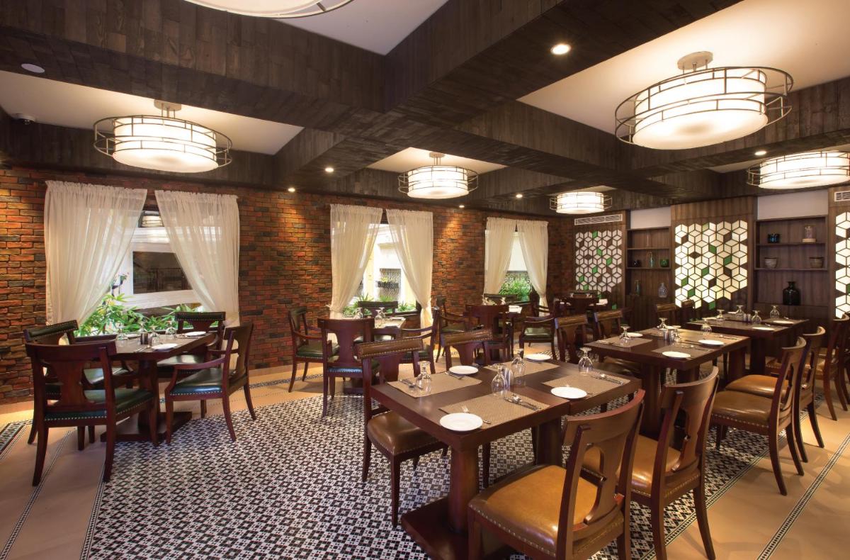 a restaurant with tables and chairs in a room at Fragrant Nature Kochi - A Five star Classified Hotel in Cochin