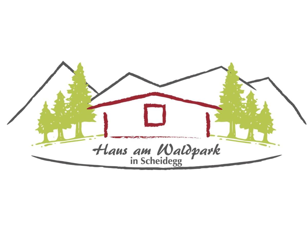 ein wunderbares Urlaubsschild vor einem Haus mit Bäumen haben in der Unterkunft Haus am Waldpark in Scheidegg