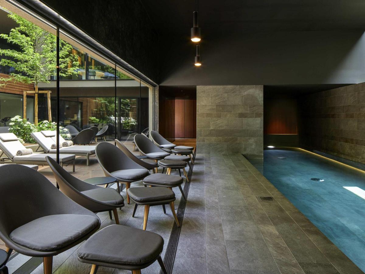 une salle d'attente avec des chaises et une piscine dans l'établissement L'Esquisse Hotel & Spa Colmar - MGallery Collection, à Colmar