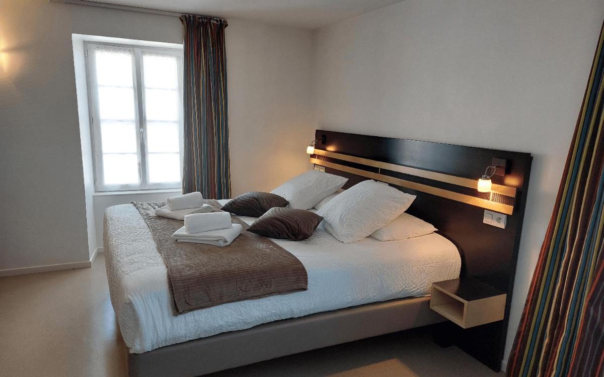 Un ou plusieurs lits dans un hébergement de l'établissement Logis Hôtel Restaurant Auberge de la Xaintrie
