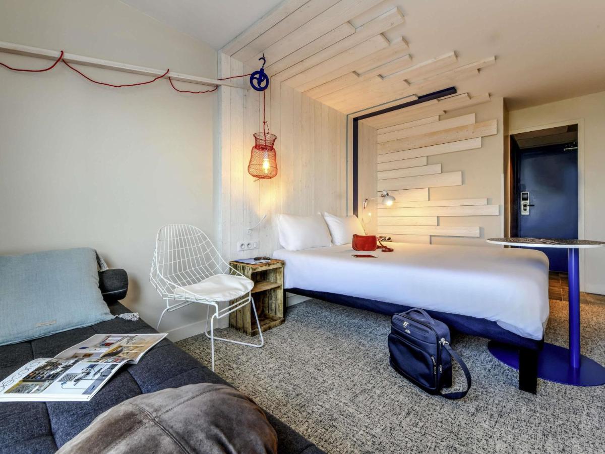 une chambre d'hôtel avec un lit et un canapé dans l'établissement ibis styles La Rochelle Thalasso Chatelaillon, à Châtelaillon-Plage