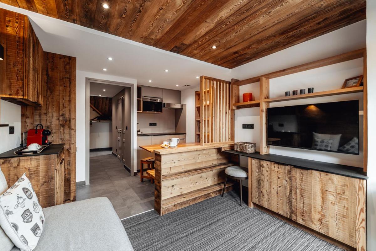 une cuisine avec des armoires en bois et un comptoir dans une pièce dans l'établissement Alliey & Spa Piscine Appart-hôtel Serre chevalier, au Monêtier-les-Bains