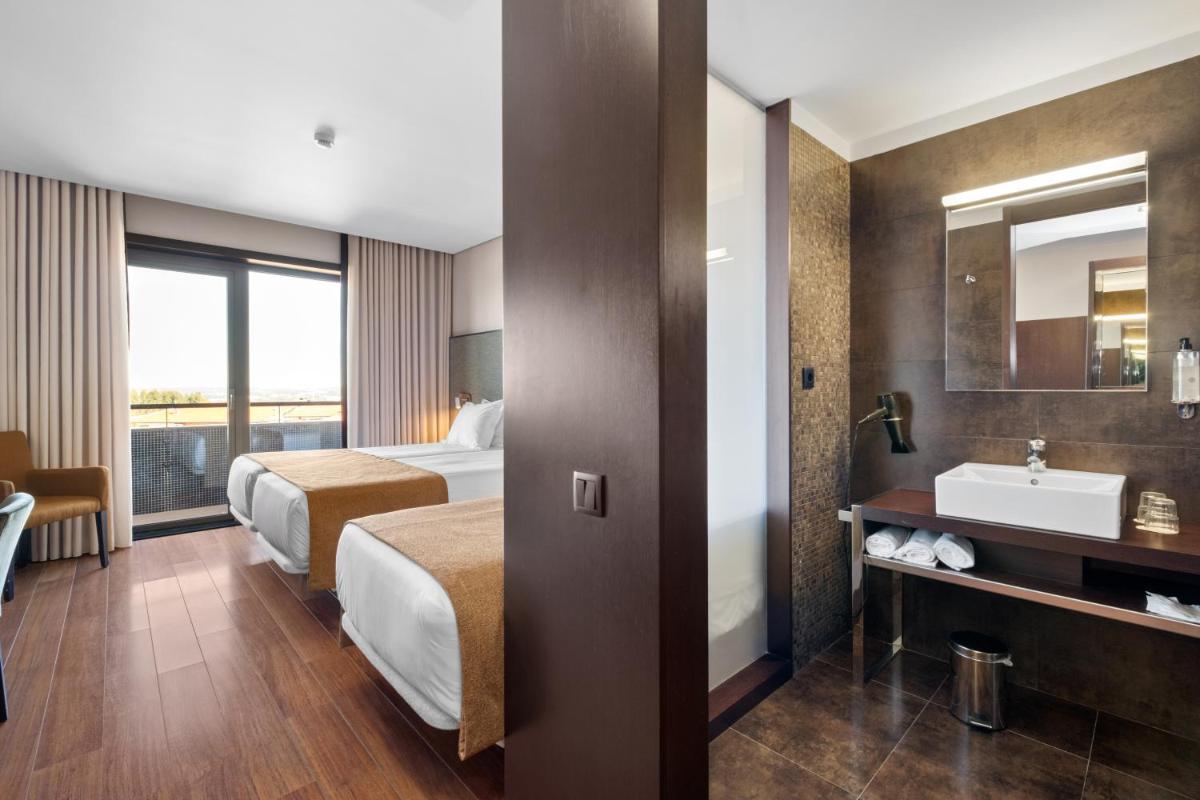 Uma cama ou camas num quarto em Axis Porto Business & Spa Hotel