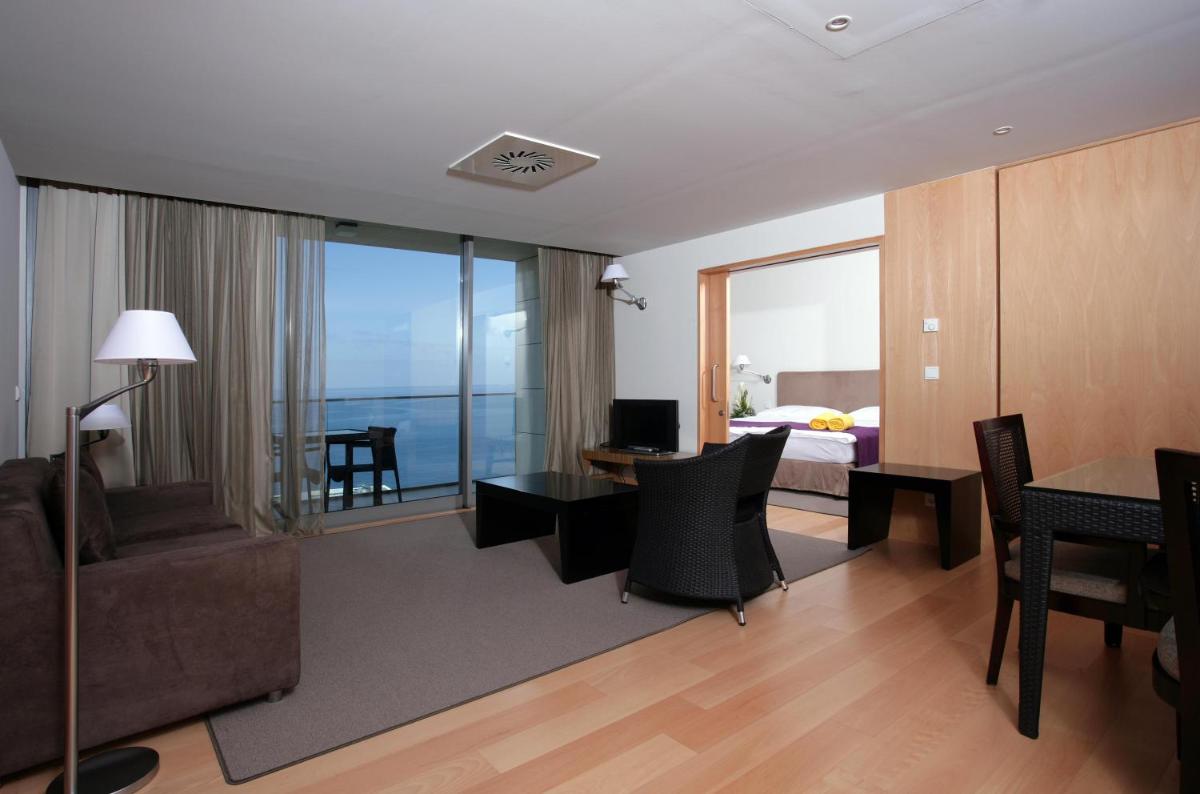 um quarto de hotel com uma cama e uma sala de estar em Golden Residence Hotel no Funchal