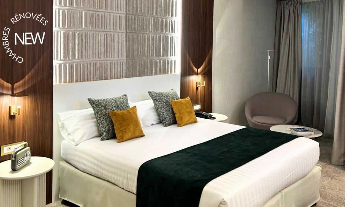 une chambre d'hôtel avec un lit et une chaise dans l'établissement Hotel Palladia, à Toulouse