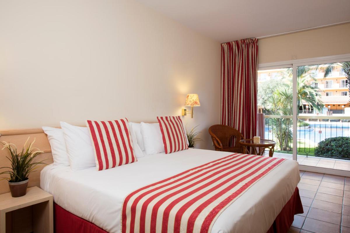 Un dormitorio con una cama y una ventana grande. en Luna Club Hotel Yoga & Spa 4Sup, en Malgrat de Mar