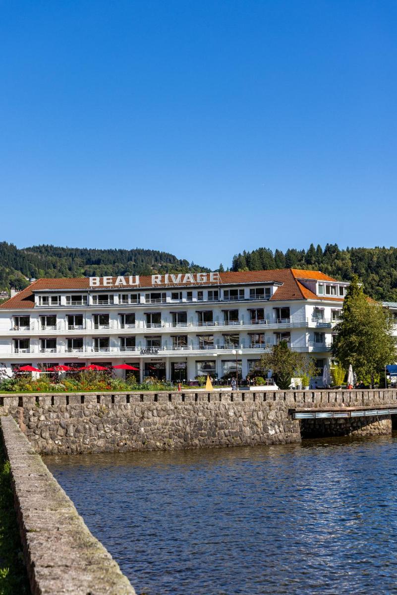 un grand hôtel au bord d'une étendue d'eau dans l'établissement Hôtel Beau Rivage, à Gérardmer