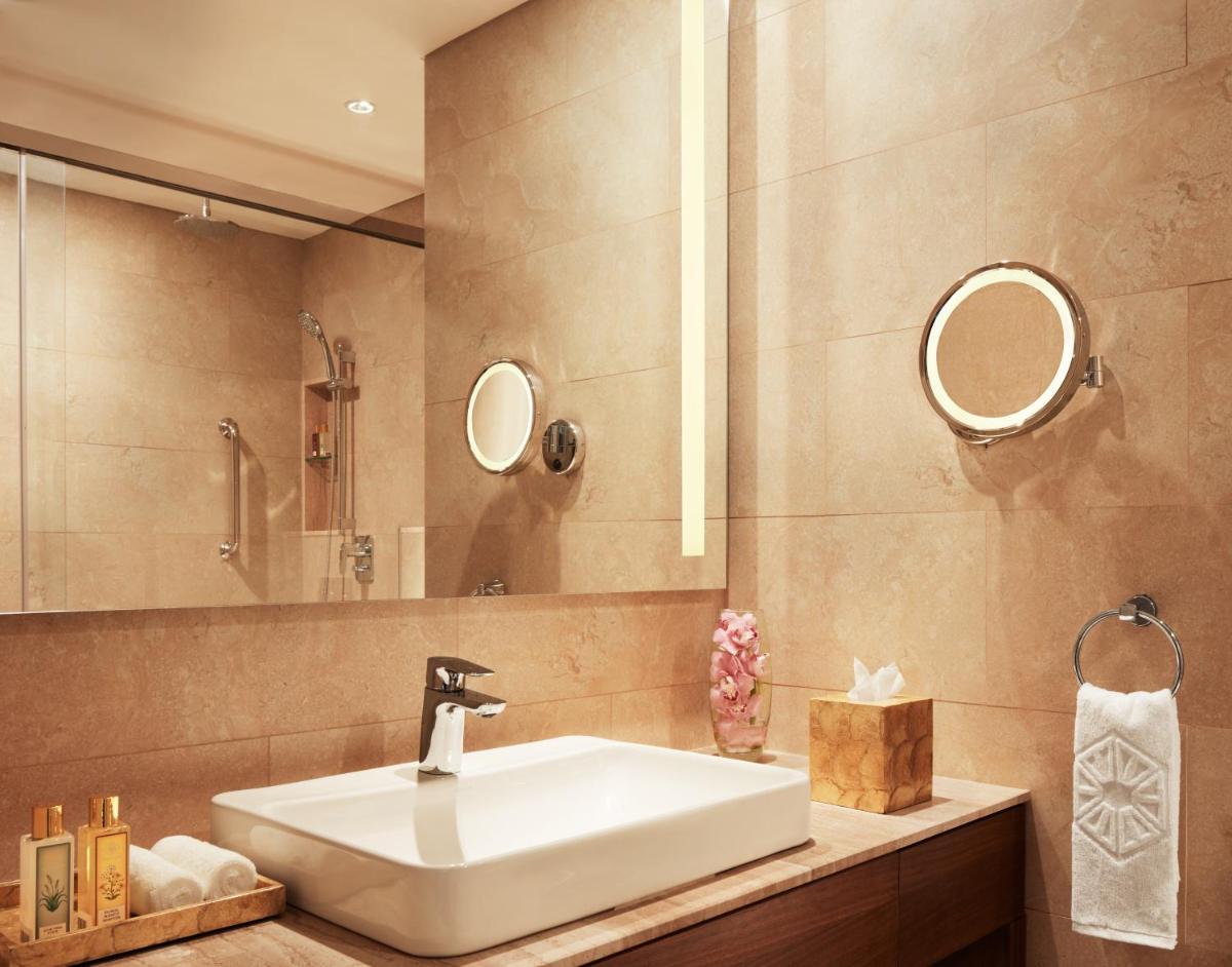 a bathroom with a sink and a mirror at Taj Swarna, Amritsar in Amritsar