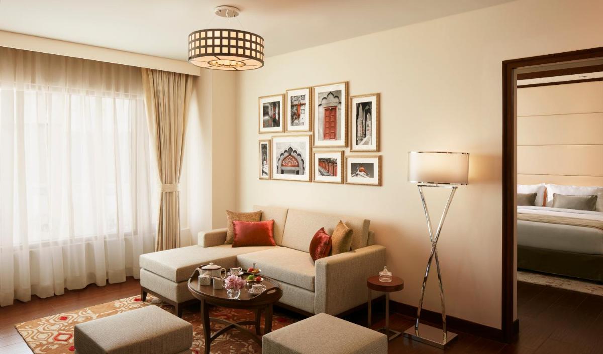 a living room with a couch and a bed at Taj Swarna, Amritsar in Amritsar