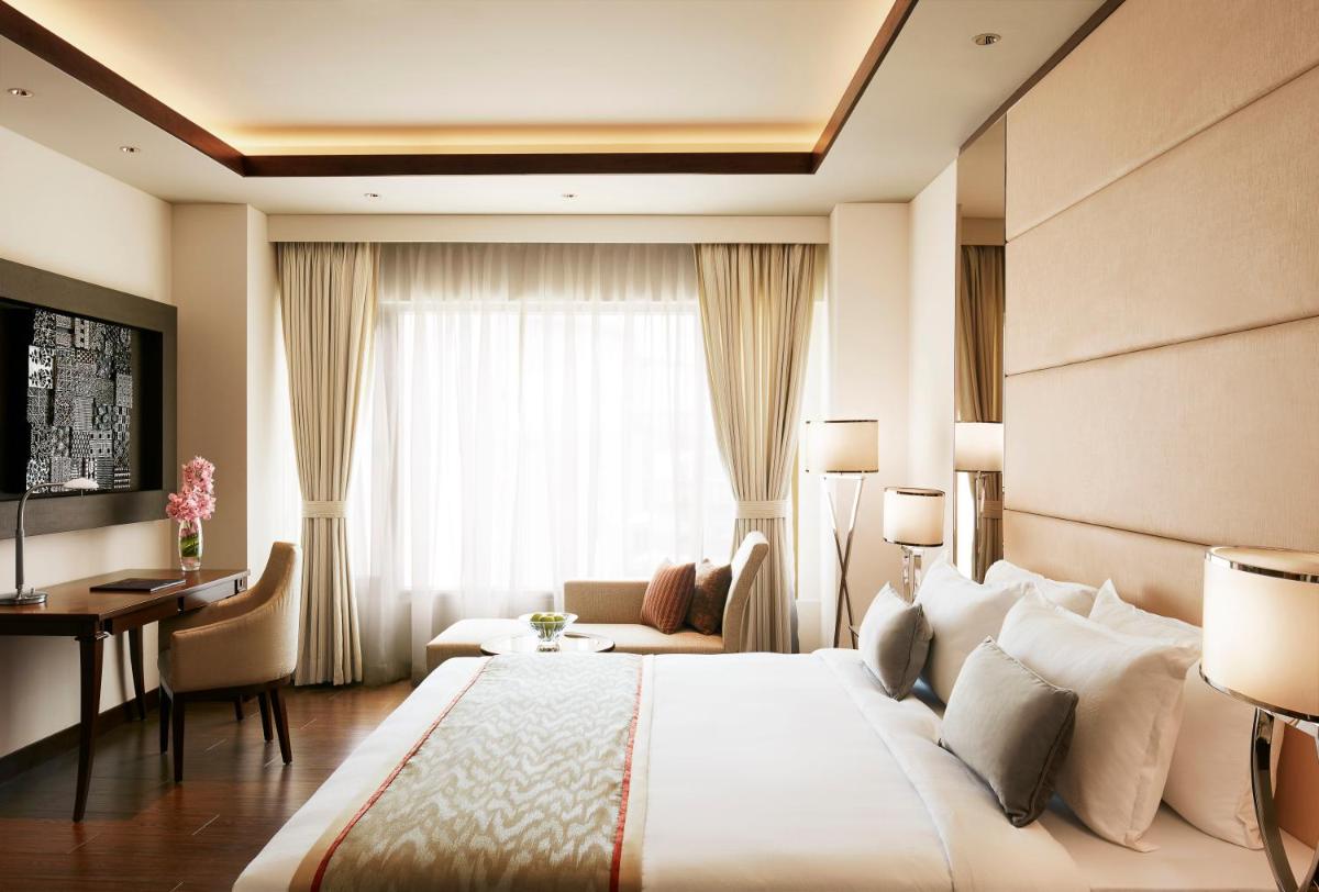 a hotel room with a large bed and a desk at Taj Swarna, Amritsar in Amritsar