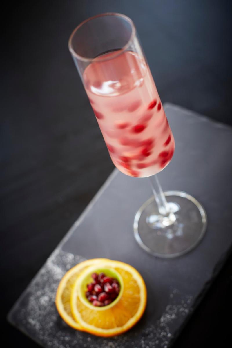 a drink in a glass next to an orange slice at Taj Swarna, Amritsar in Amritsar