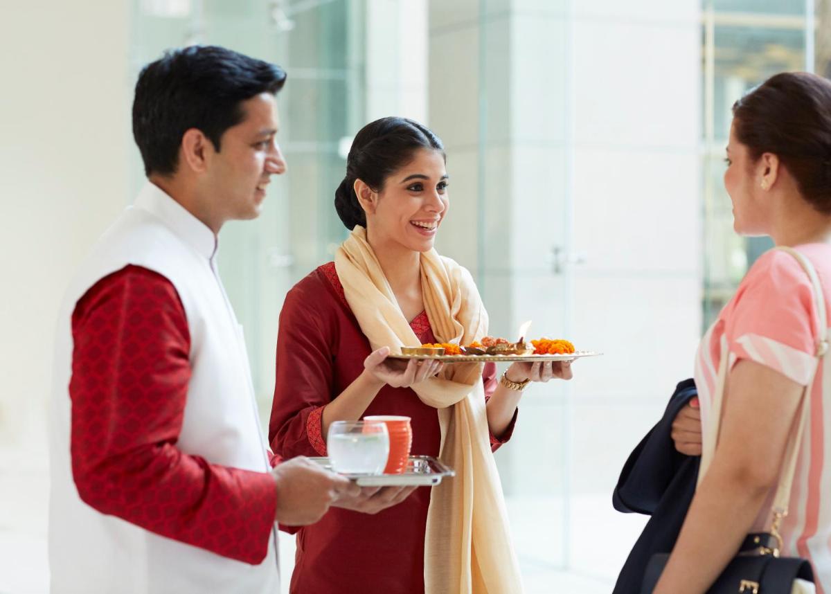 a woman holding a plate of food with a man at Taj Swarna, Amritsar in Amritsar