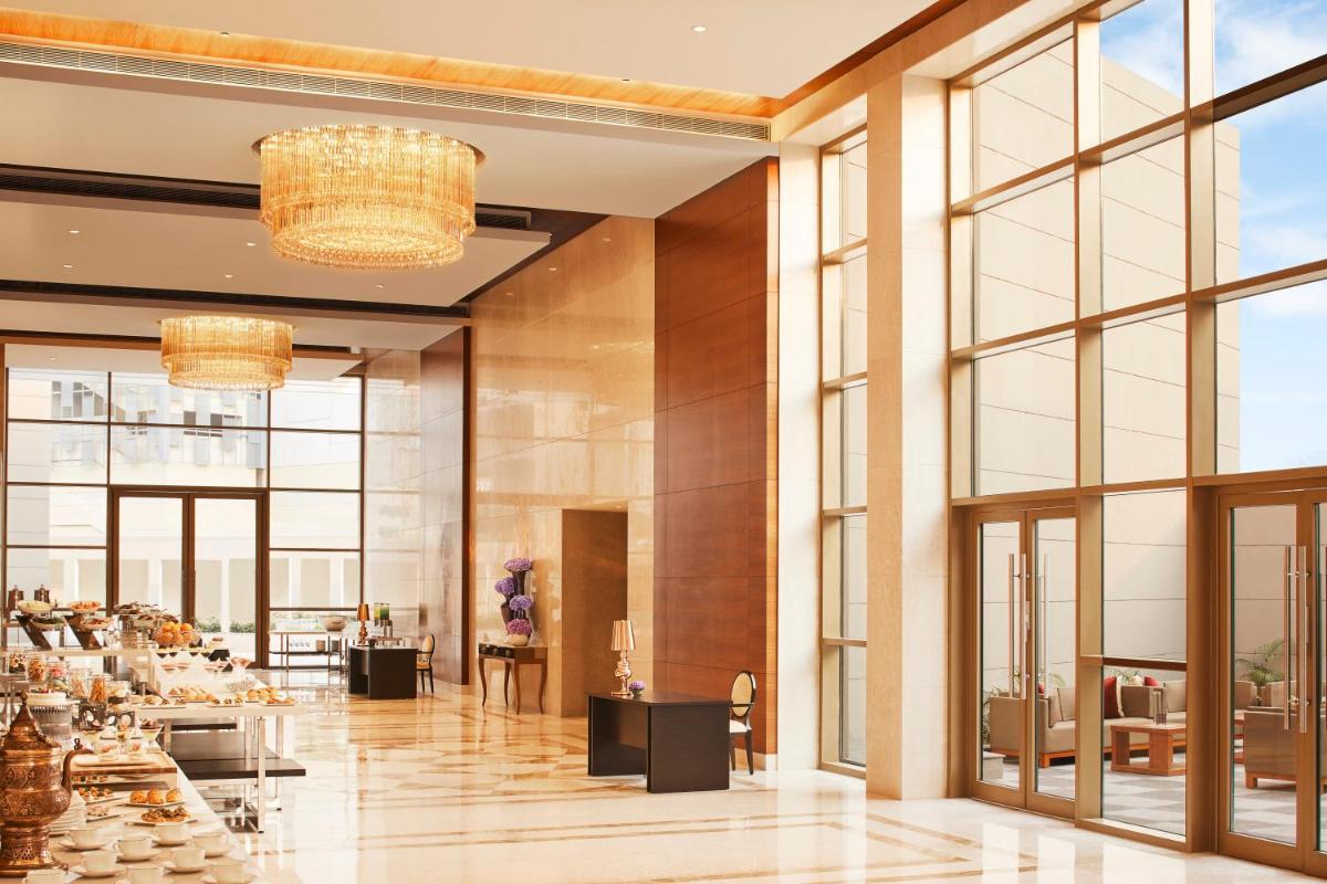 a lobby of a hotel with windows and a restaurant at Taj Swarna, Amritsar in Amritsar