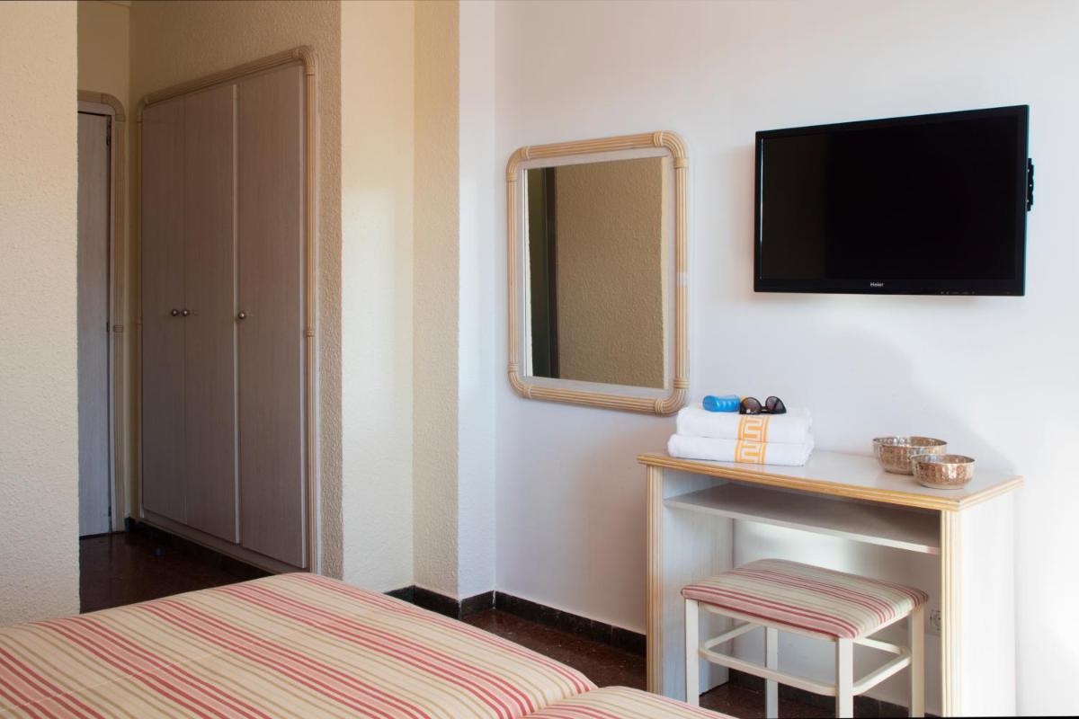 Un dormitorio con una cama y un televisor en la pared. en Luna Park Hotel Yoga & Spa, en Malgrat de Mar