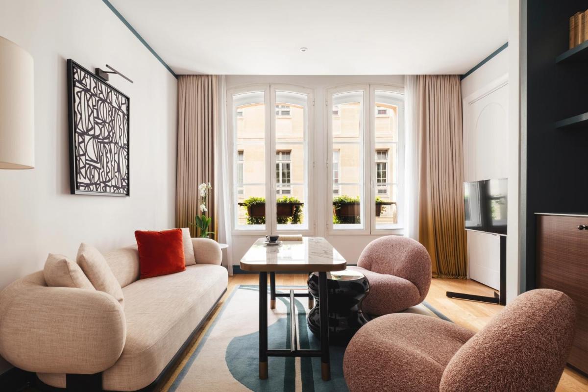 un salon avec un canapé, des fauteuils et une table dans l'établissement Hôtel Bel Ami, à Paris