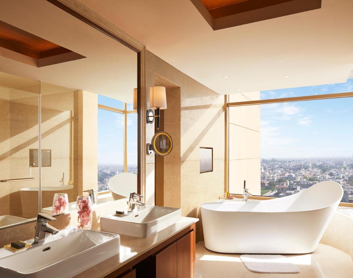a bathroom with two sinks and a large window at Taj Swarna, Amritsar in Amritsar