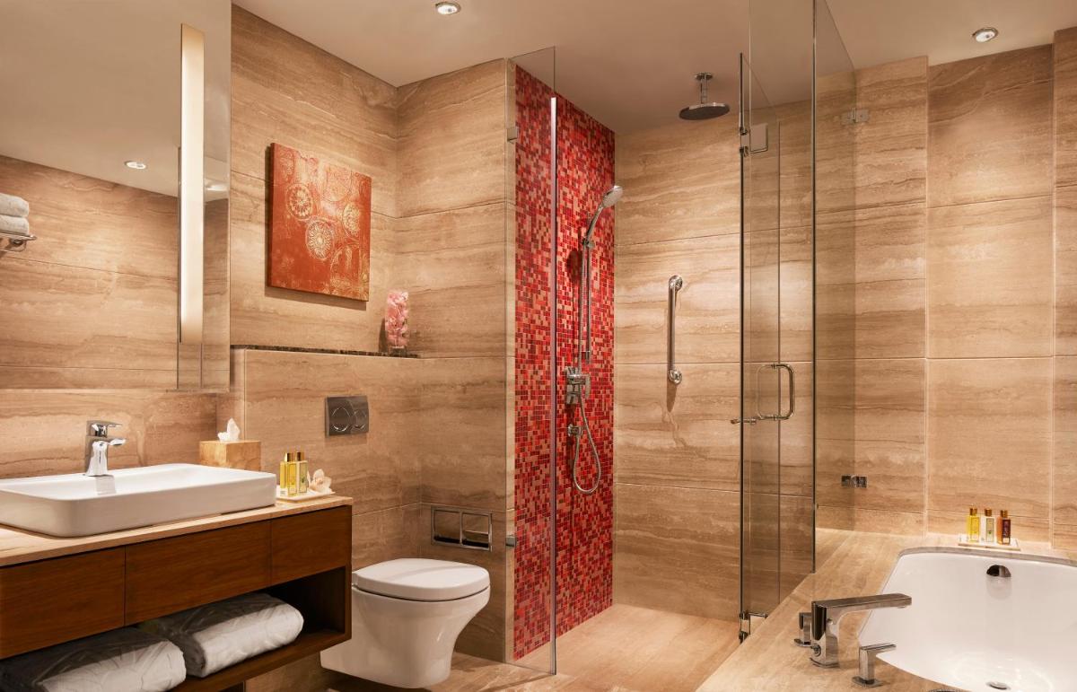 a bathroom with a sink toilet and a shower at Taj Swarna, Amritsar in Amritsar