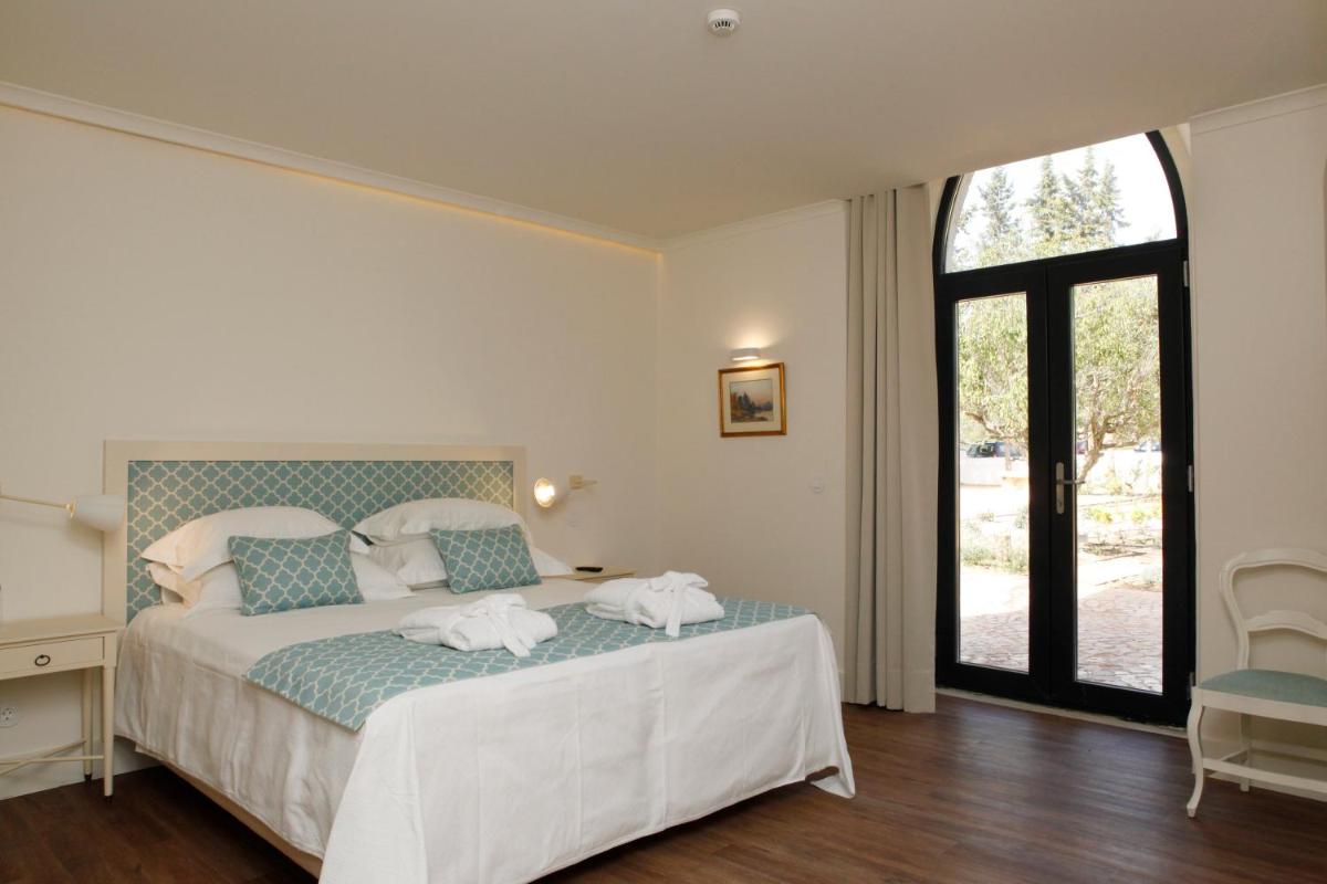 Uma cama ou camas num quarto em Hotel Casa Palmela - Small Luxury Hotels of The World, Hotel & Villas
