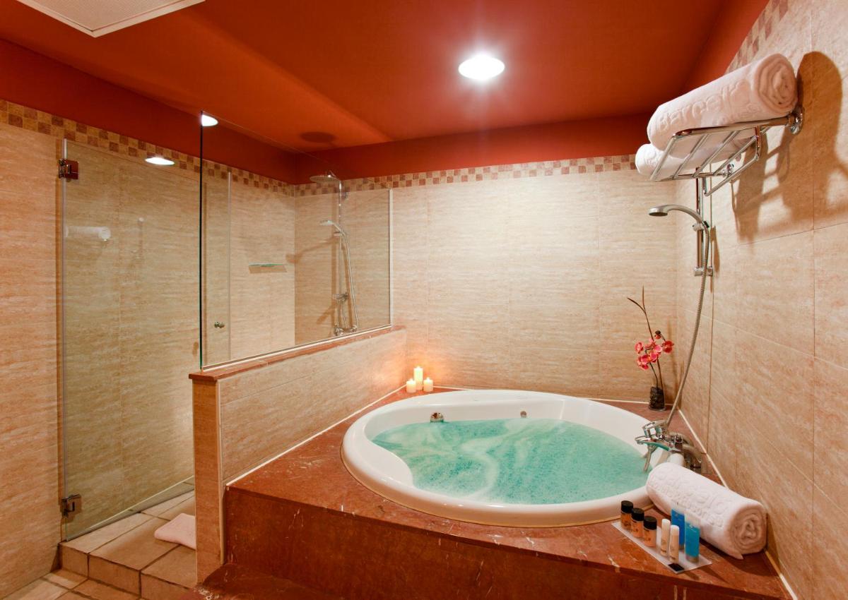 baño con bañera de hidromasaje y ducha en Occidental Jandía Royal Level - Adults Only, en Morro del Jable