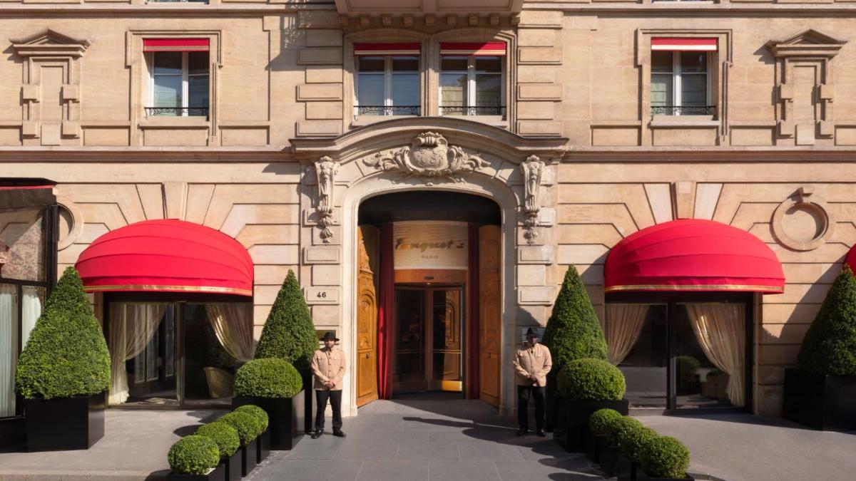 un bâtiment avec deux hommes debout devant dans l'établissement Hôtel Fouquet's Paris, à Paris