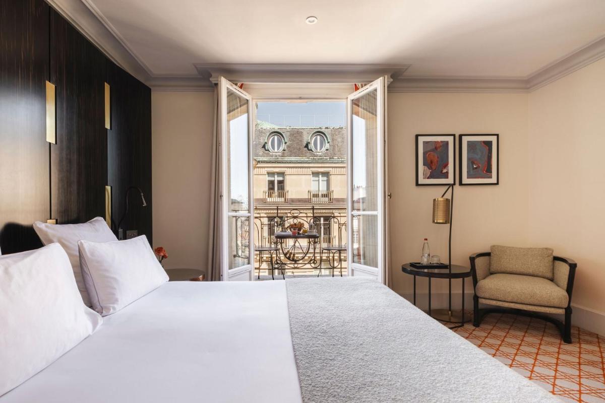 une chambre avec un grand lit blanc et une fenêtre dans l'établissement Hotel Montalembert, à Paris