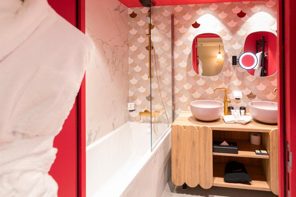 une salle de bains avec deux lavabos et une douche dans l'établissement Black Bass Hotel, à Sévrier