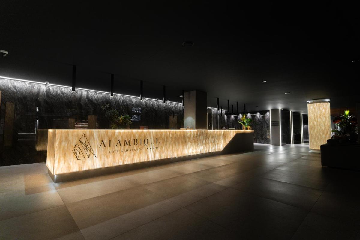 um banco com inscrições em um prédio à noite em Alambique - Hotel Resort & Spa no Fundão