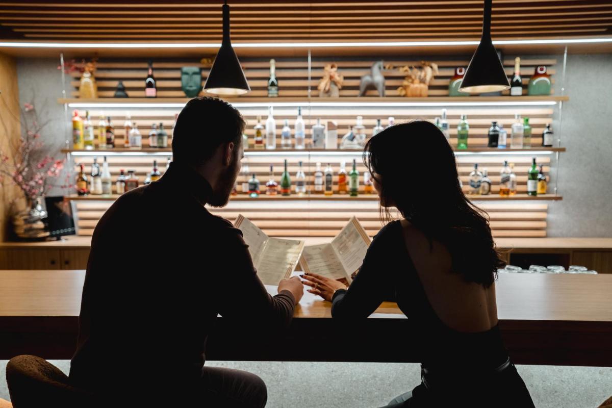 um homem e uma mulher sentados à mesa em uma loja em Alambique - Hotel Resort & Spa no Fundão