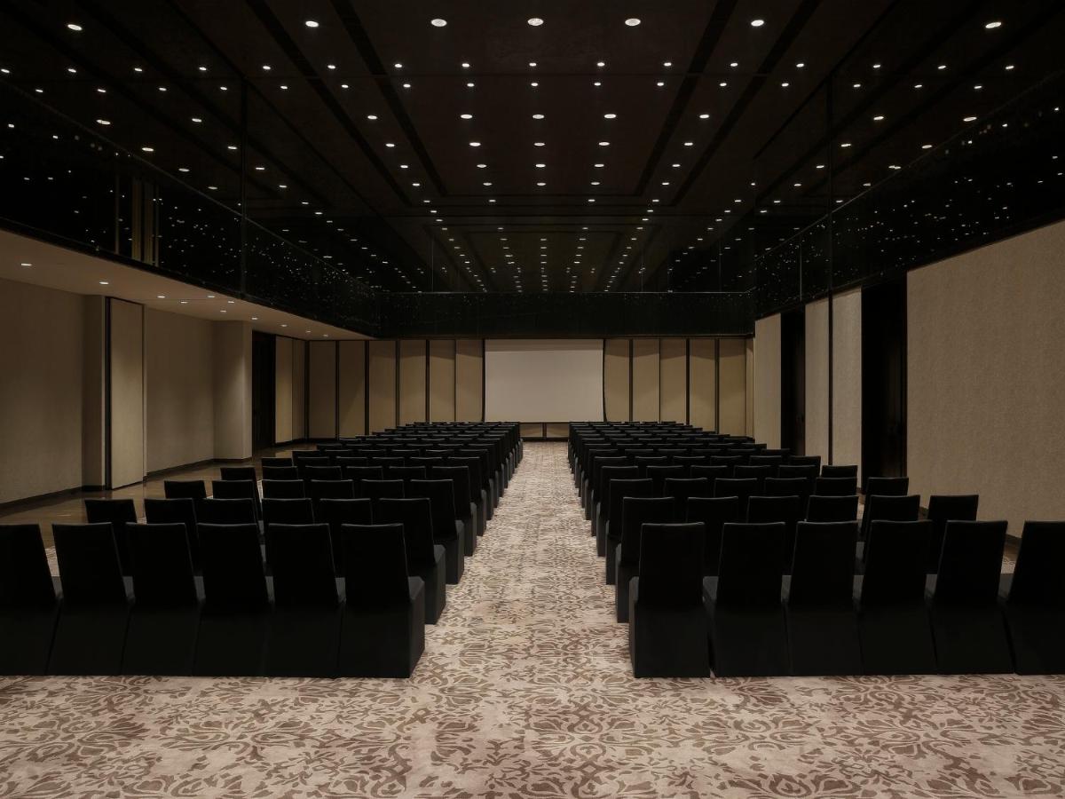 an empty room with black chairs and a stage at Roseate House New Delhi in New Delhi +75 photos an empty room with black chairs and a stage at Roseate House New Delhi in New Delhi +75 photos