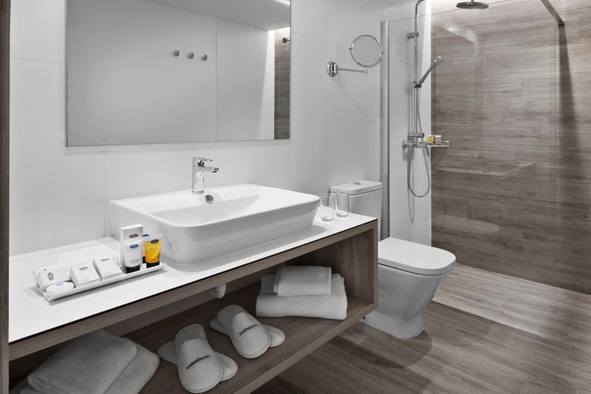 Un baño con lavabo, inodoro y ducha. en Elba Premium Suites - Adults Only, en Playa Blanca