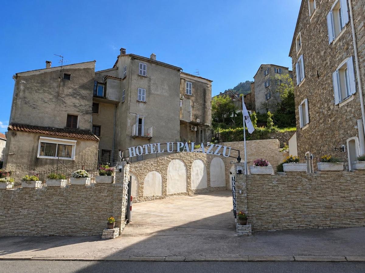 une entrée d'un vieux bâtiment avec un portail dans l'établissement Hôtel U Palazzu & Spa, à Venaco