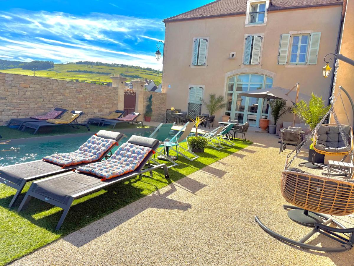 une cour arrière avec des chaises, une piscine et une maison dans l'établissement Les Rêveries du Clos POMMARD Vignes & SPA& Dégustation, à Pommard