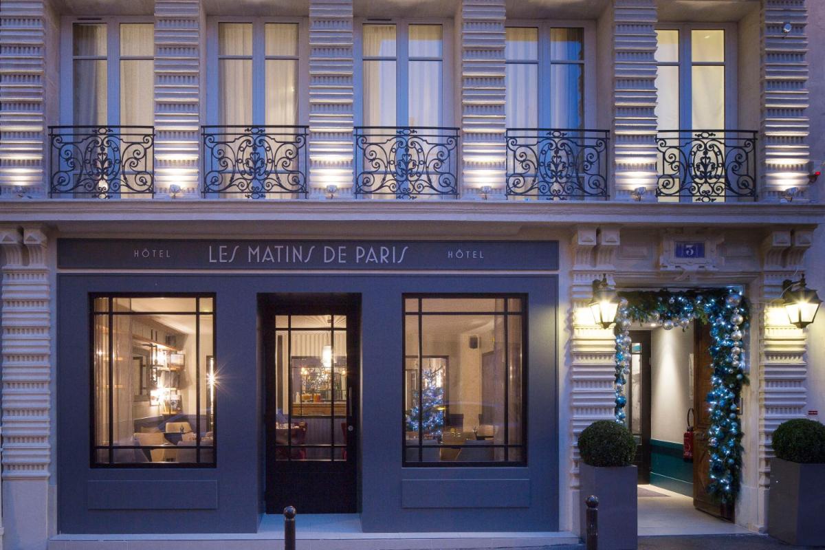 une façade de bâtiment avec un arbre de Noël devant dans l'établissement Les Matins de Paris & Spa, à Paris