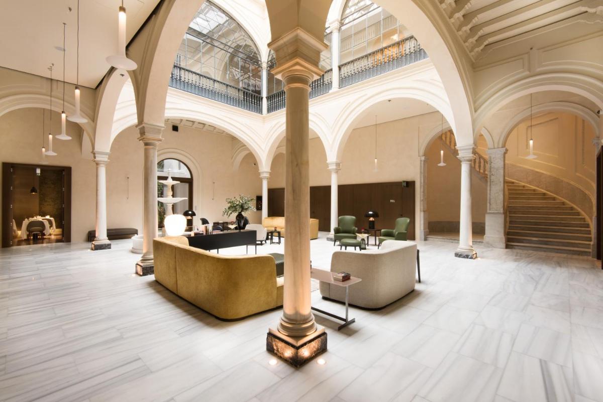 un gran edificio con un vestíbulo con mesas y sillas en Hotel Mercer Sevilla 5 GL, en Sevilla