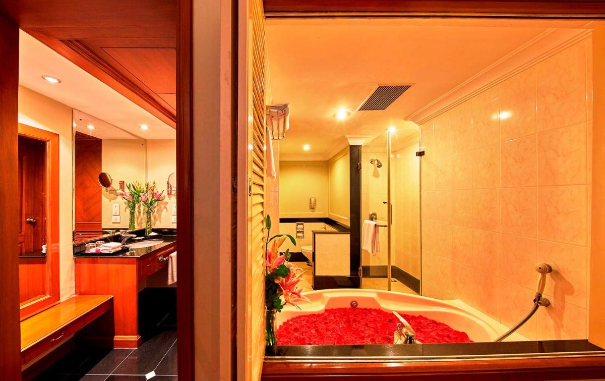 a bathroom with a bath tub in a room at Hotel Royal Orchid Bangalore in Bengaluru