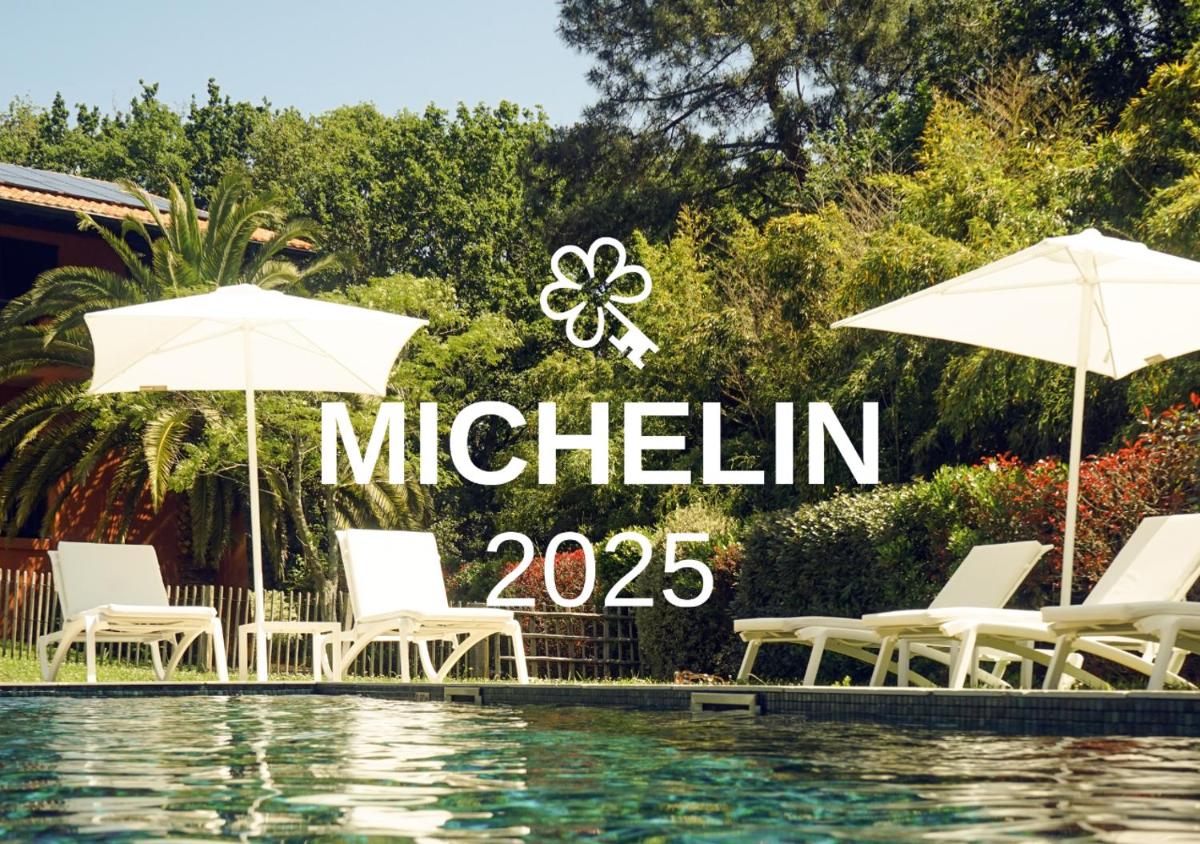 un groupe de chaises et de parasols à côté d'une piscine dans l'établissement Les Frères Ibarboure - Hôtel 4 étoiles, Spa extérieur sensoriel et Restaurant étoilé à Bidart, à Bidart