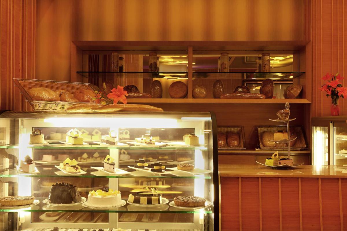 a display case in a bakery with cakes and pastries at The Metropolitan Hotel & Spa New Delhi in New Delhi