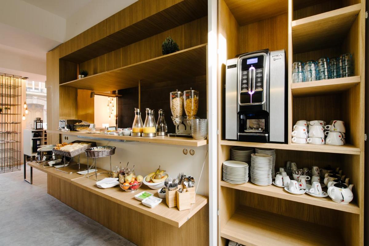 une cuisine avec un comptoir avec des assiettes et un micro-ondes dans l'établissement Atypik Hotel, à Clichy