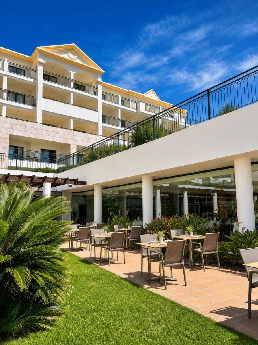 Vista externa de um hotel com mesas e cadeiras. em Cerro Mar Atlantico & Cerro Mar Garden em Albufeira