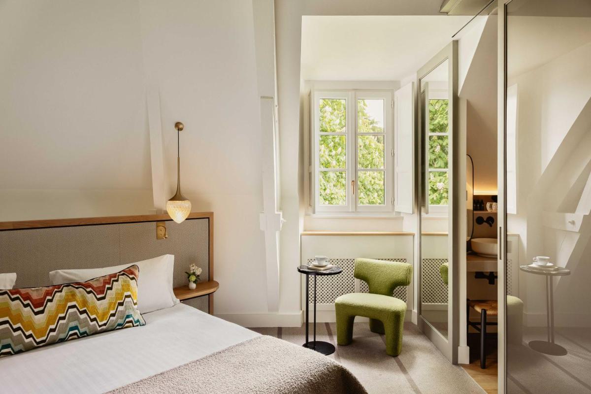 une chambre avec un lit et une chaise verte dans l'établissement Hôtel & Spa de La Bretesche, à Missillac 81 autres photos