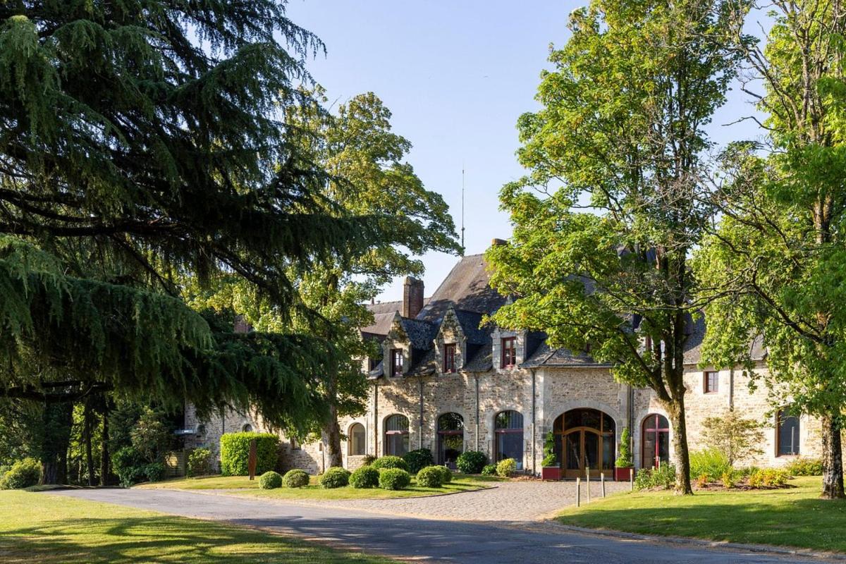 une grande maison en pierre avec une allée dans l'établissement Hôtel & Spa de La Bretesche, à Missillac