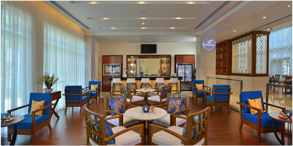 a dining room with tables and blue chairs at Fortune Miramar, Goa - Member ITC Hotels' Group in Panaji a dining room with tables and blue chairs at Fortune Miramar, Goa - Member ITC Hotels' Group in Panaji