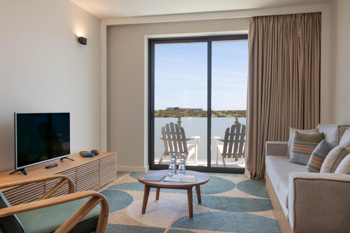 uma sala de estar com um sofá e uma TV em Memmo Baleeira - Design Hotels em Sagres