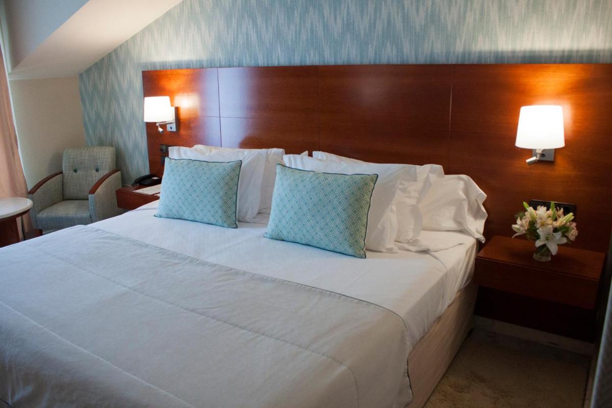 Cama o camas de una habitación en Hotel Carlos I Silgar