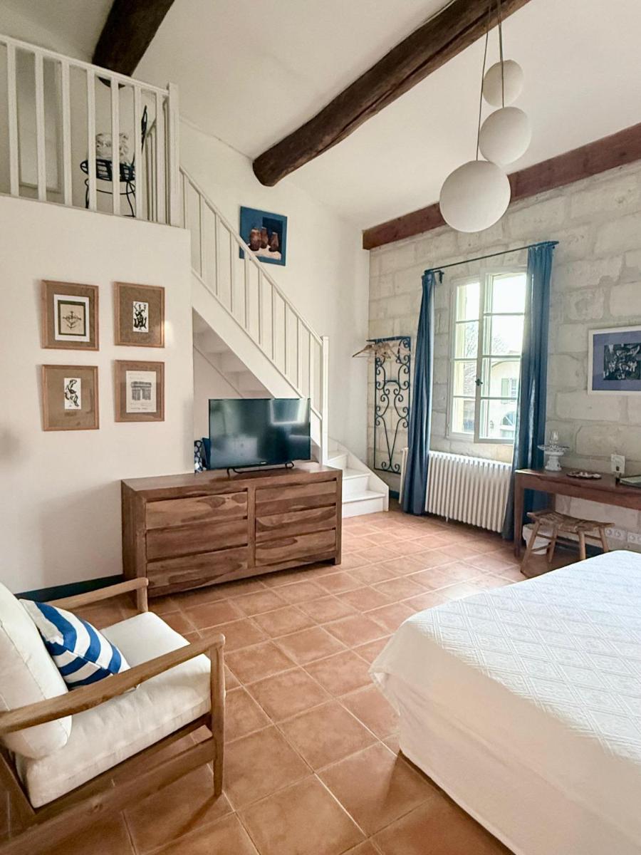 une chambre avec un lit, une télévision et un escalier dans l'établissement HOTEL et APPARTEMENTS DOMAINE DES CLOS - Teritoria, à Beaucaire