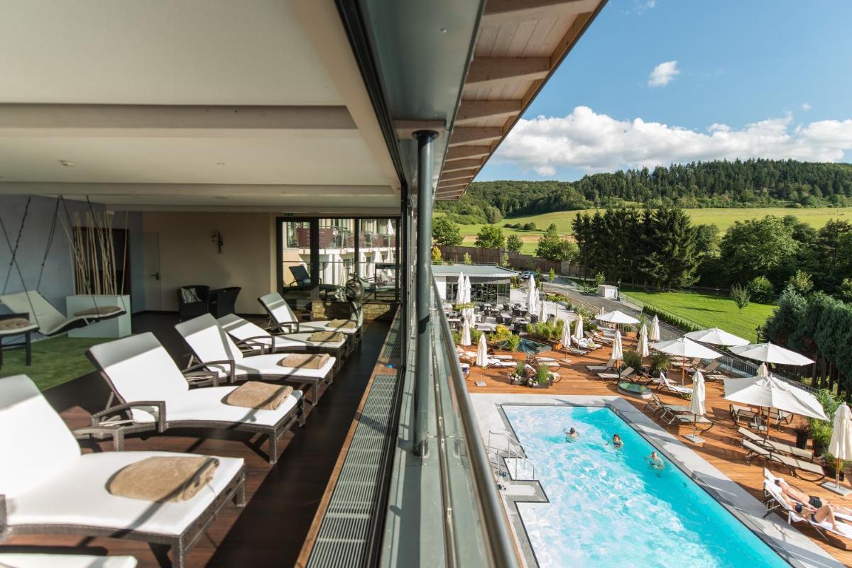 einen Balkon mit Liegestühlen und einem Pool in der Unterkunft Göbels Schlosshotel "Prinz von Hessen" in Friedewald einen Balkon mit Liegestühlen und einem Pool in der Unterkunft Göbels Schlosshotel "Prinz von Hessen" in Friedewald