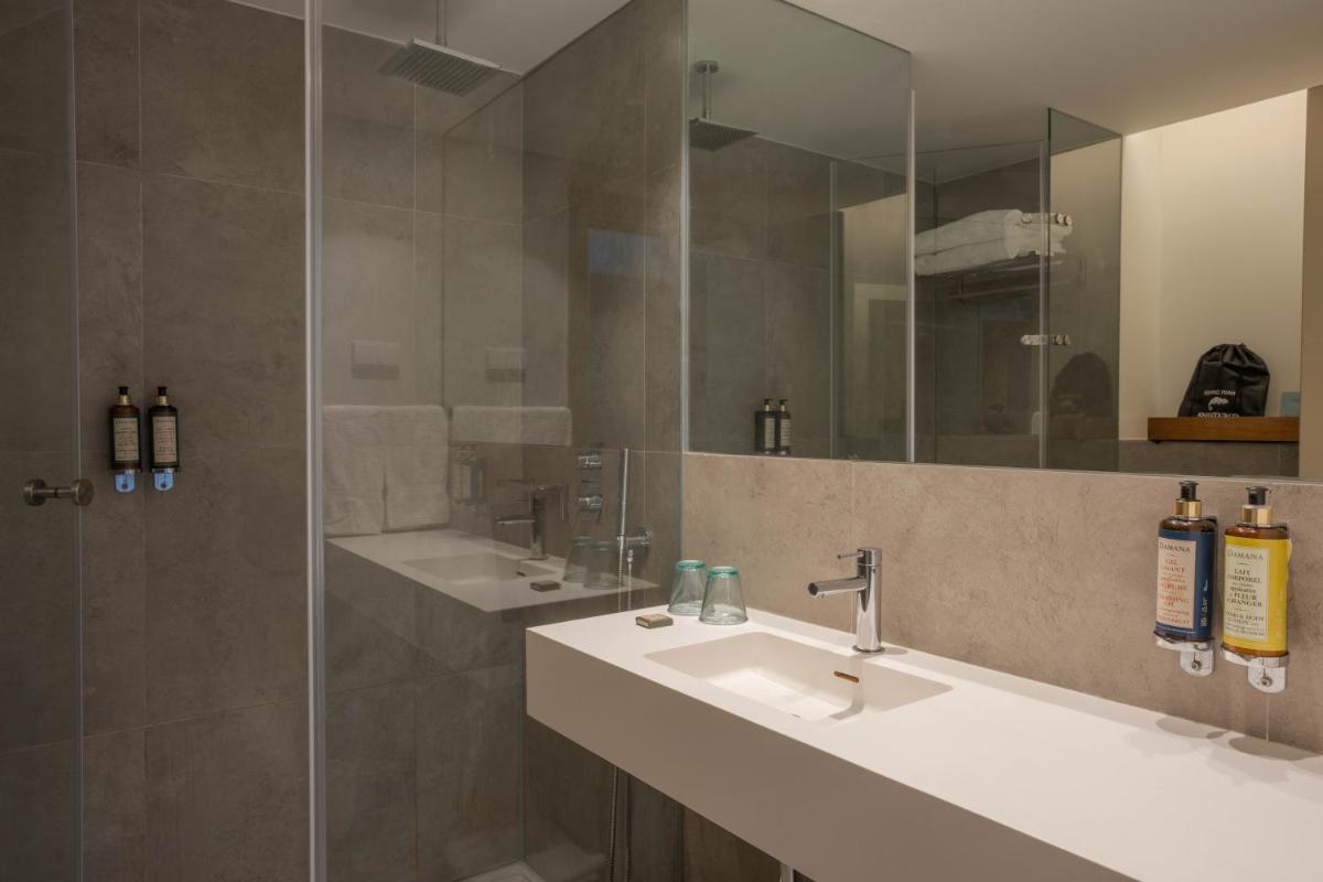 um banheiro com duas pias e um chuveiro em Memmo Baleeira - Design Hotels em Sagres